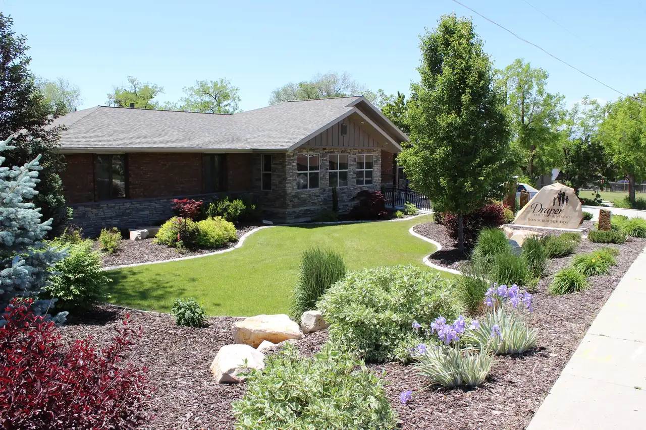 The Draper Parkway Dental building at 946 East Draper Parkway, with its gardens and the stone sign at the road.