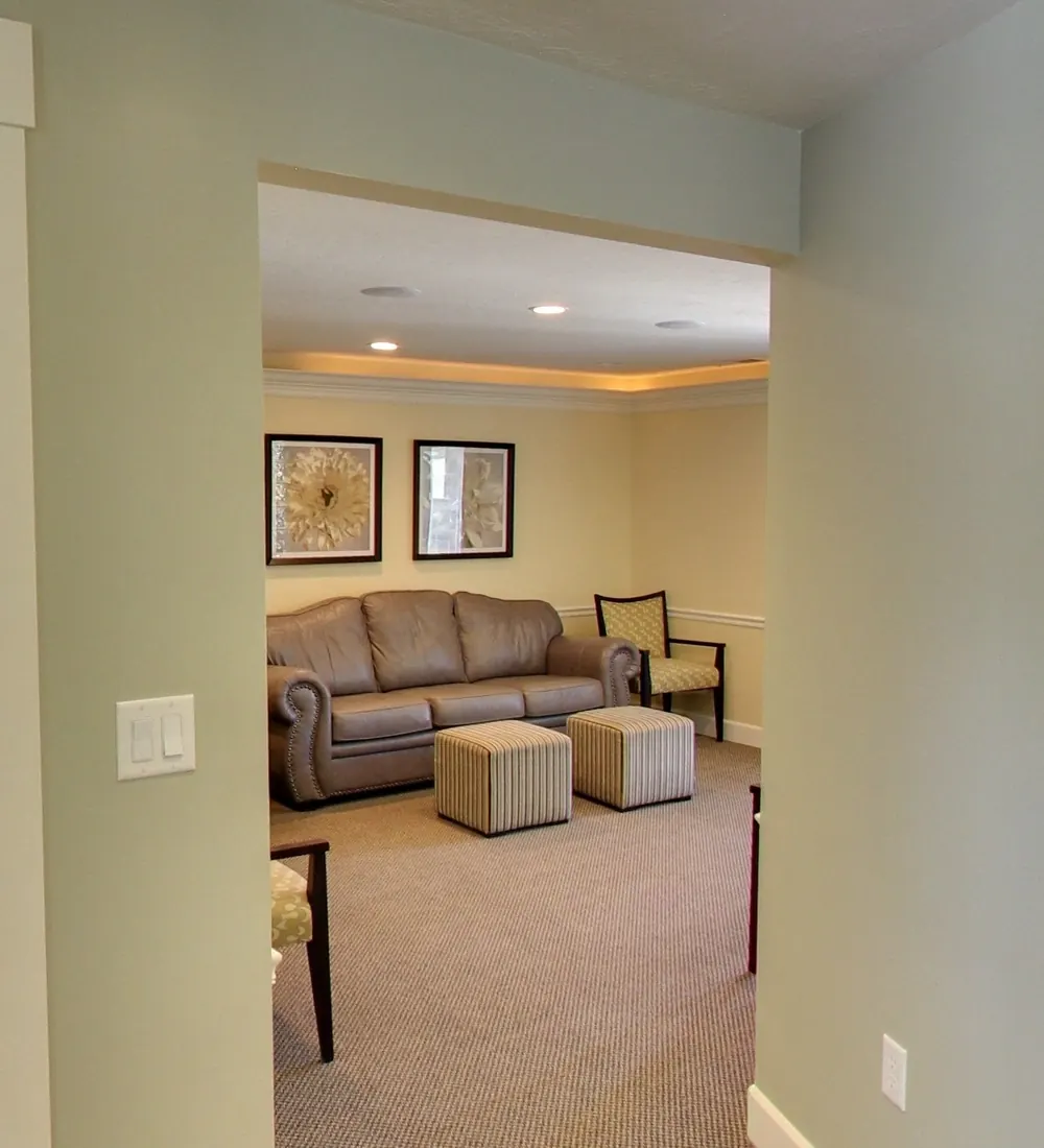 The lounge area inside Draper Parkway Dental, with a sofa and footstools.