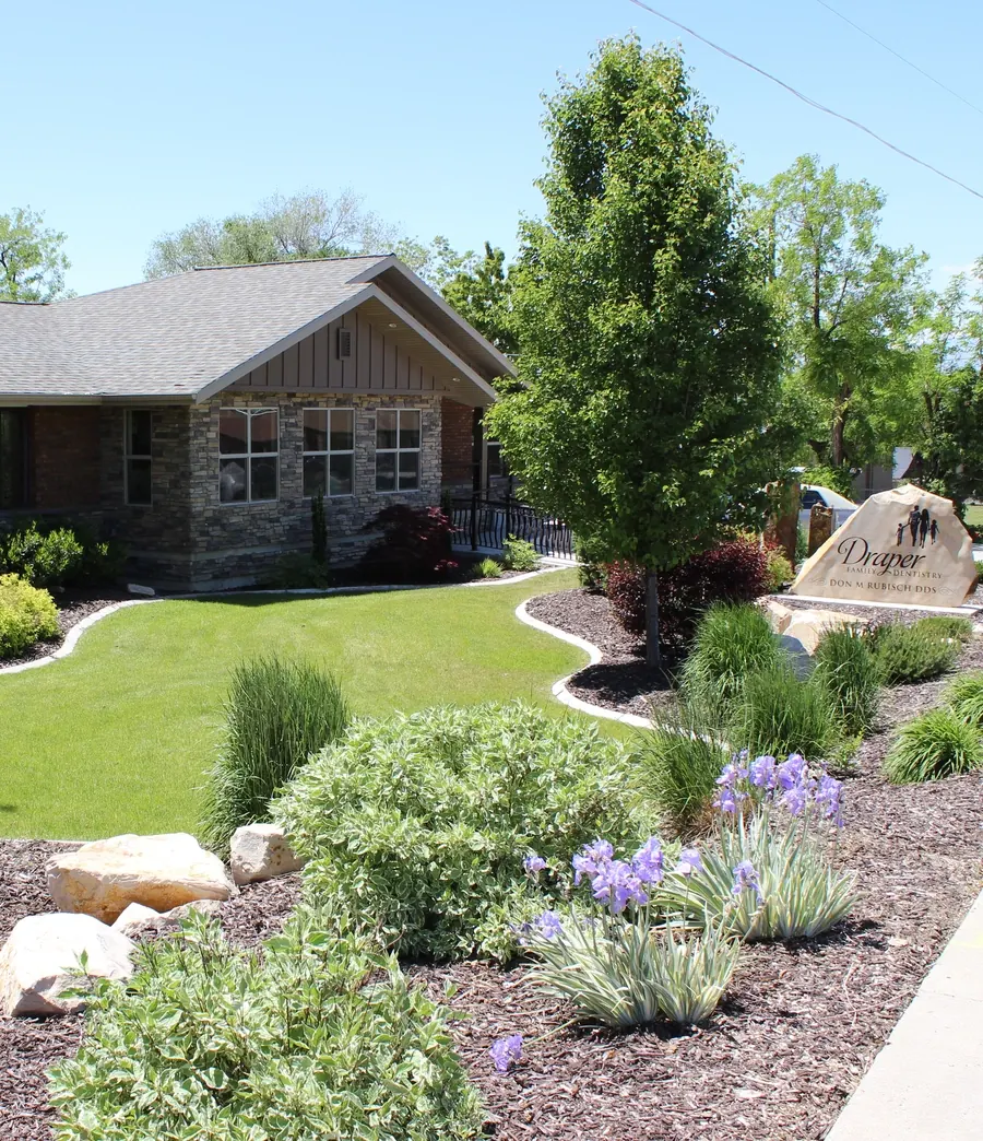 The gardens and stone sign in front of Draper Parkway Dental.